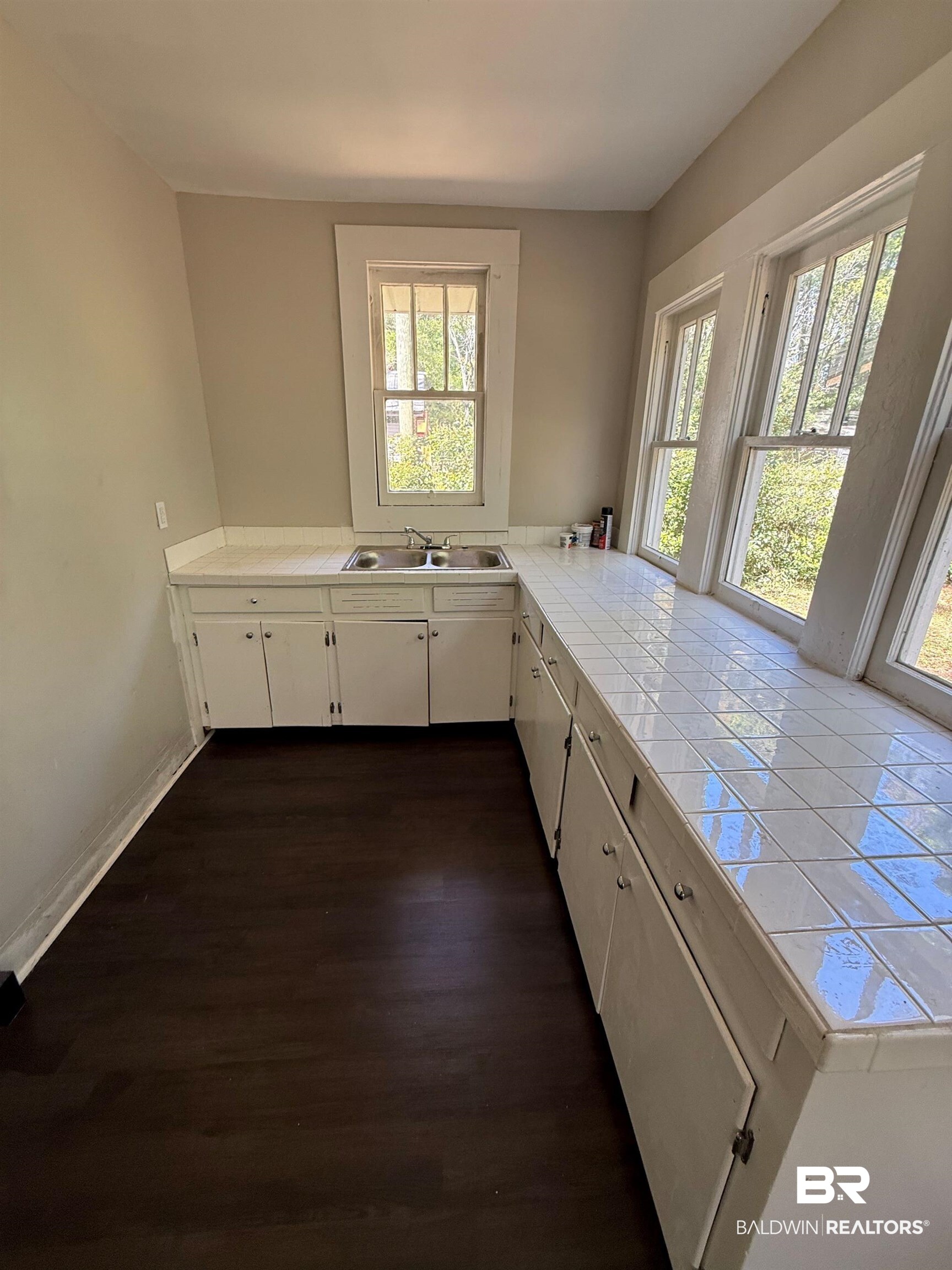 655 Mandrell Street Mobile, AL 36606 - Photo 5 of 12 Kitchen with tile counters, dark wood-style flooring, and white cabinetry