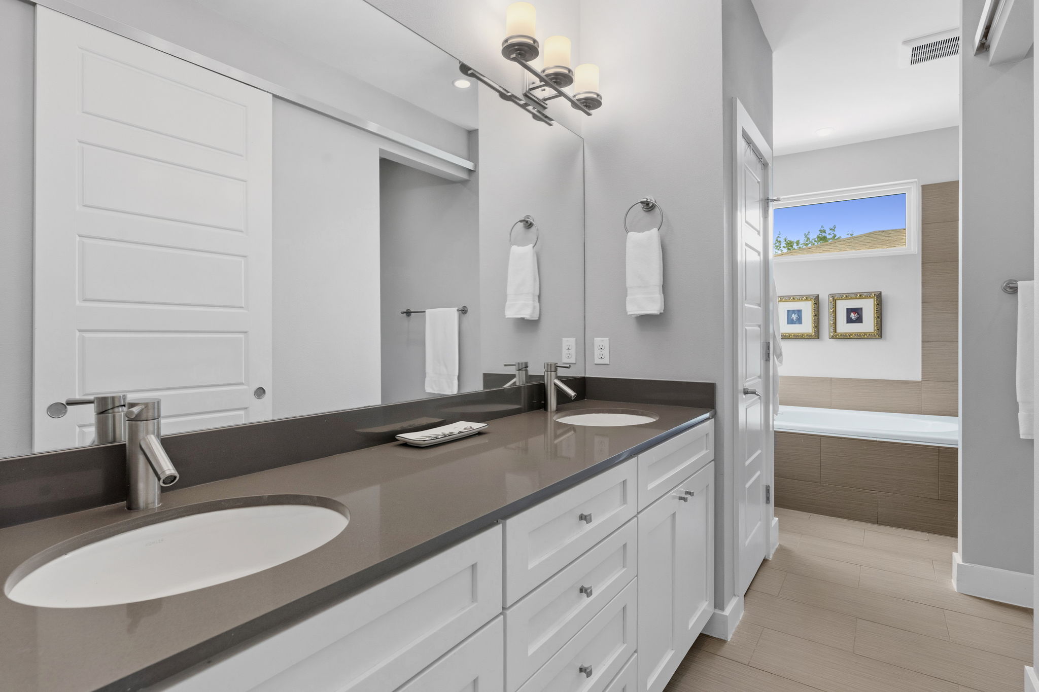 1303 Azie Morton Road, Unit 2 Austin, TX 78704 - Photo 20 of 36 a bathroom with a granite countertop sink a mirror and a bathtub