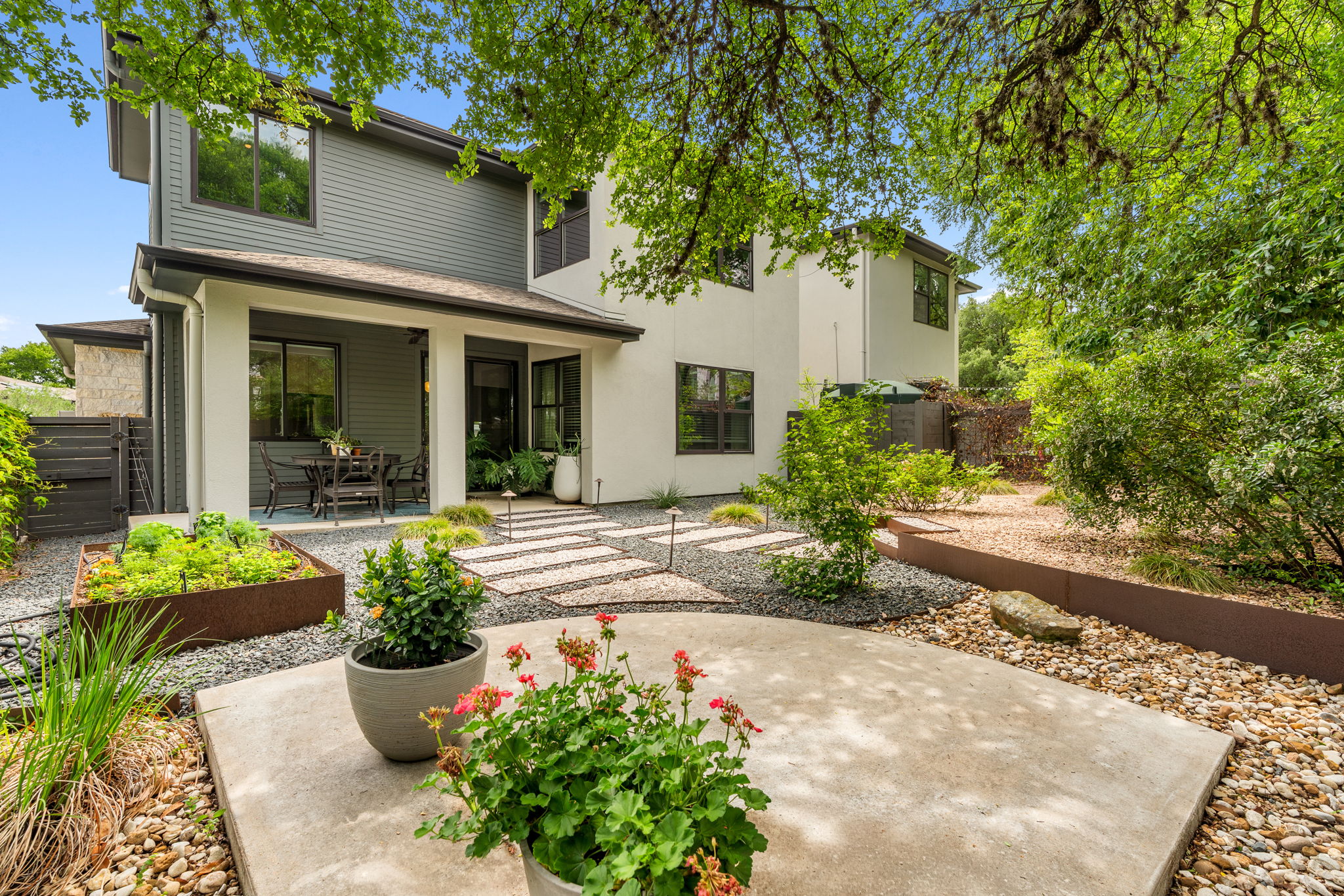 1303 Azie Morton Road, Unit 2 Austin, TX 78704 - Photo 30 of 37 Backyard features a covered patio for outdoor seating and a landscaped yard with gravel pathways and greenery.