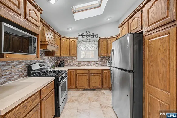 a kitchen with stainless steel appliances granite countertop a refrigerator a stove a sink and dishwasher
