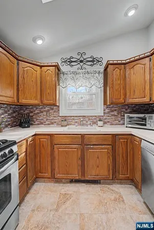 a kitchen with stainless steel appliances granite countertop a sink stove and cabinets