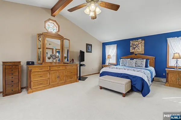 a spacious bedroom with a bed and a chandelier