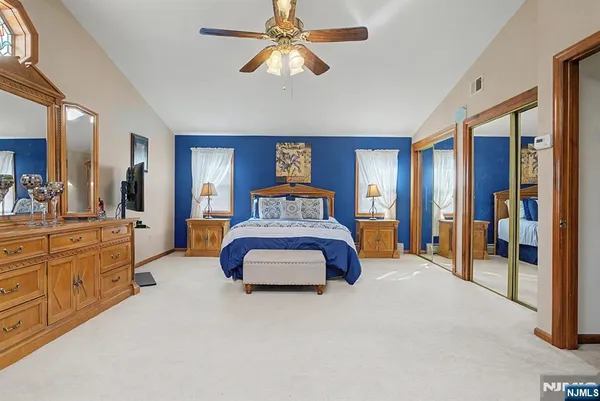 a bedroom with a large bed and a chandelier