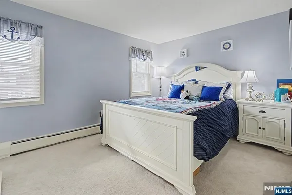 a bathroom with a granite countertop sink a toilet and a window