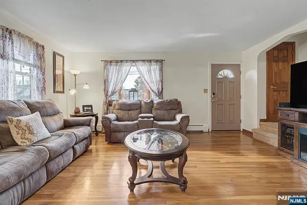a living room with furniture a flat screen tv and a table