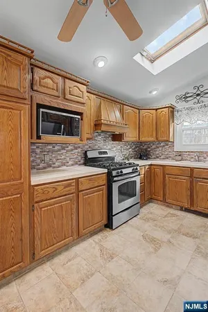 a kitchen with stainless steel appliances granite countertop a stove sink and microwave