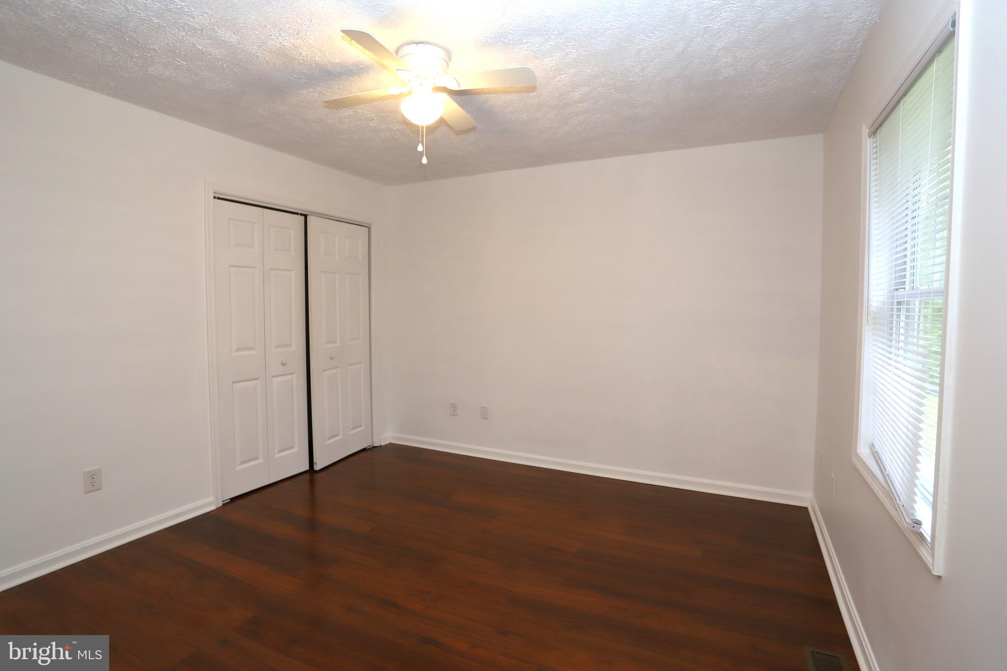 14459 Norman Road Culpeper, VA 22701 - Photo 15 of 23 an empty room with wooden floor fan and windows