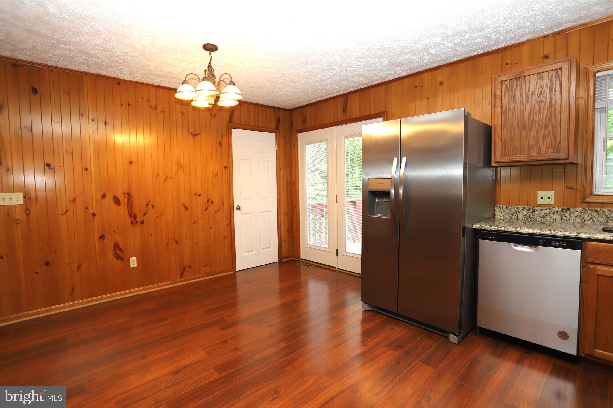 14459 Norman Road Culpeper, VA 22701 - Photo 9 of 23 an empty room with wooden floor chandelier fan and windows