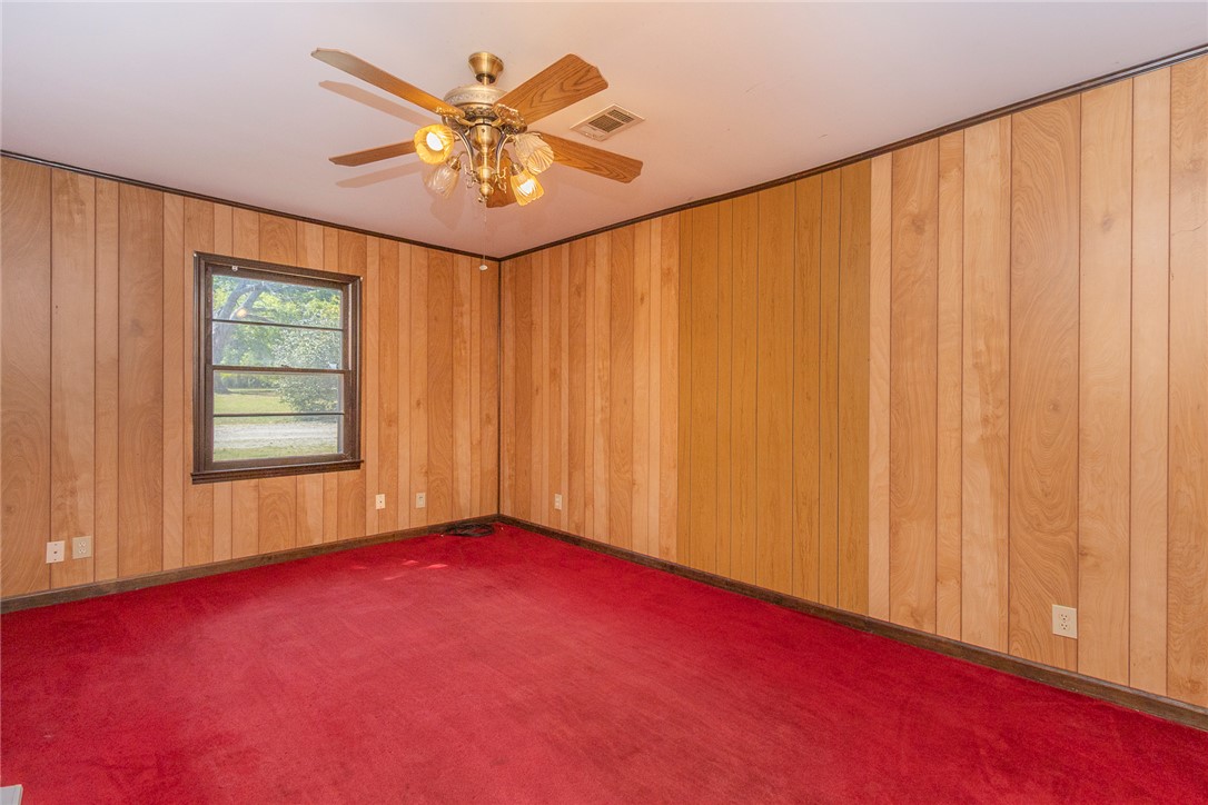 820 Travis Road Anderson, SC 29626 - Photo 26 of 46 This spacious room features wood paneling and a ceiling fan, offering a cozy and inviting atmosphere.