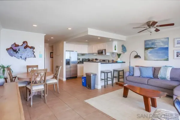 a living room with furniture and a kitchen area