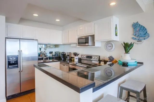 a kitchen with kitchen island granite countertop a sink stove and refrigerator