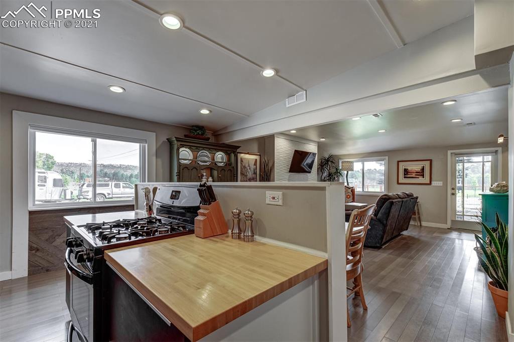 8977 Spruce Mountain Road Larkspur, CO 80118 - Photo 15 of 50 a kitchen with a table chairs stove and wooden floor
