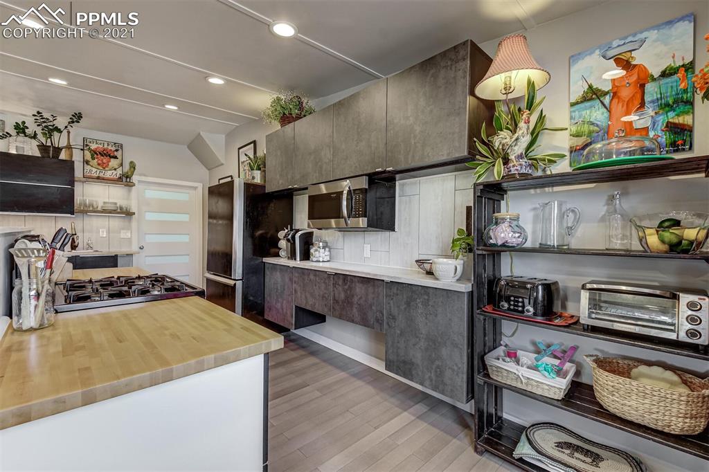 8977 Spruce Mountain Road Larkspur, CO 80118 - Photo 16 of 50 a kitchen with stainless steel appliances granite countertop a stove and cabinets