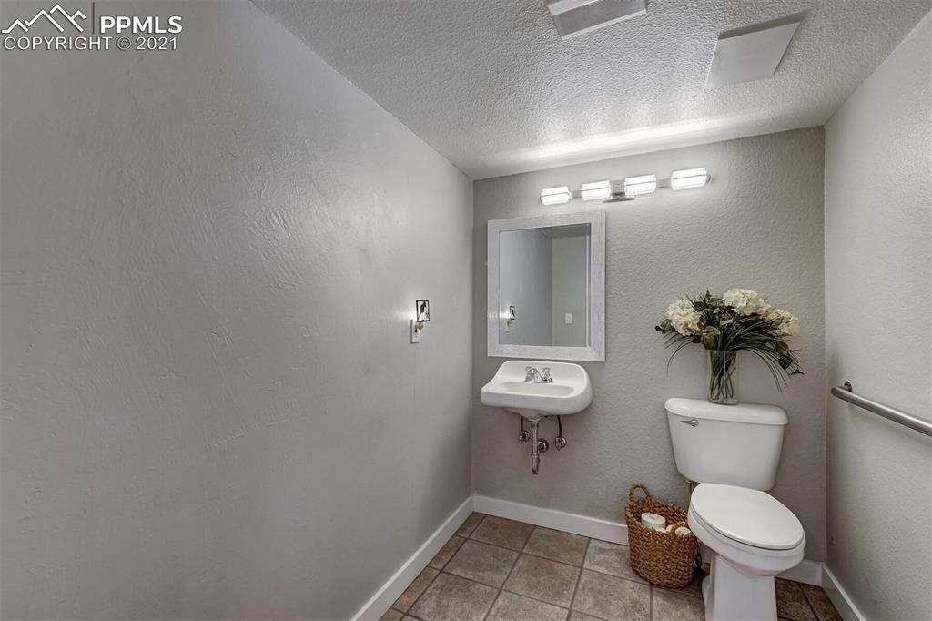8977 Spruce Mountain Road Larkspur, CO 80118 - Photo 20 of 50 a bathroom with a toilet sink and mirror