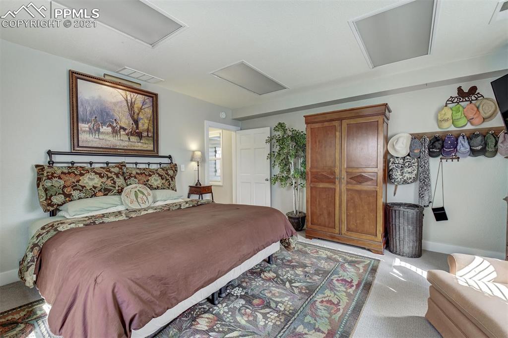 8977 Spruce Mountain Road Larkspur, CO 80118 - Photo 33 of 50 a bedroom with a bed and a painting on the wall