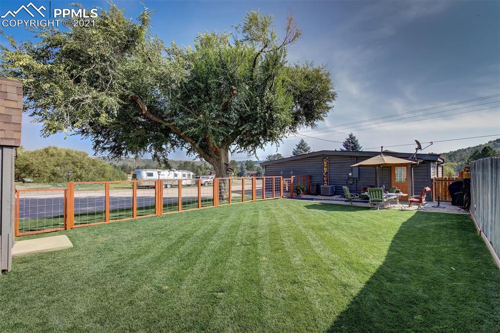 8977 Spruce Mountain Road Larkspur, CO 80118 - Photo 37 of 50 a view of a house with a big yard and large trees