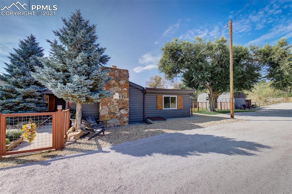 8977 Spruce Mountain Road Larkspur, CO 80118 - Photo 42 of 50 a view of a patio with a table and chairs under an umbrella
