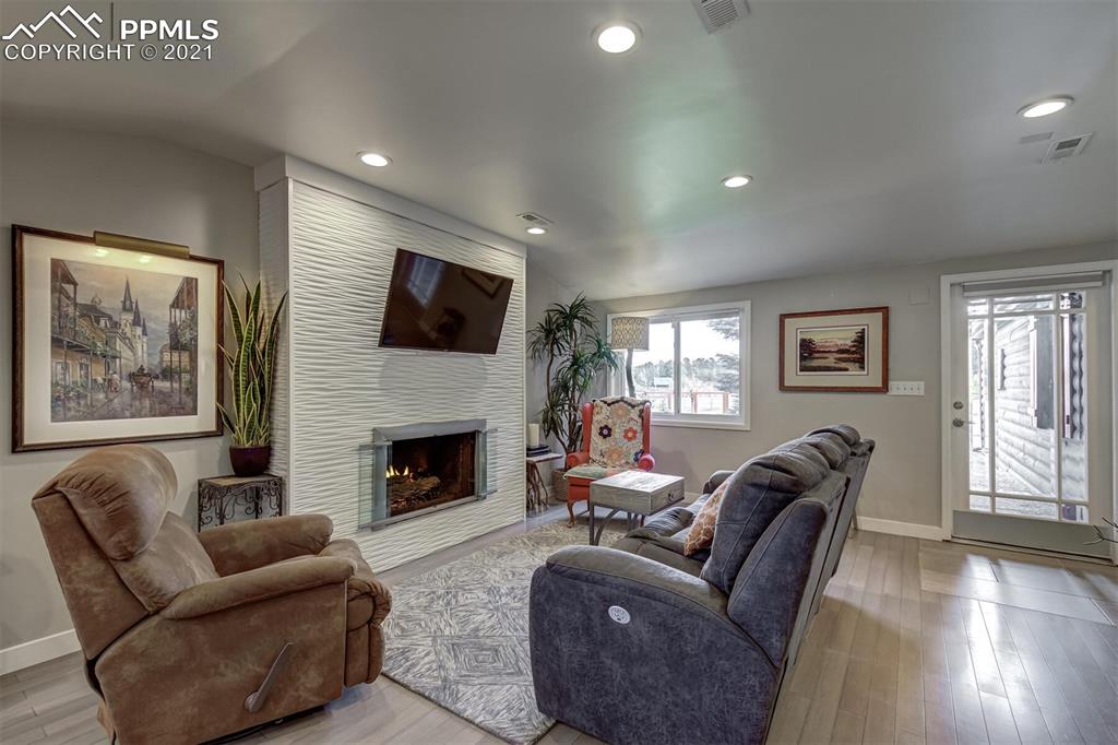 8977 Spruce Mountain Road Larkspur, CO 80118 - Photo 8 of 50 a living room with furniture a fireplace and a flat screen tv