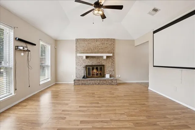 a view of an empty room with a fireplace and a window