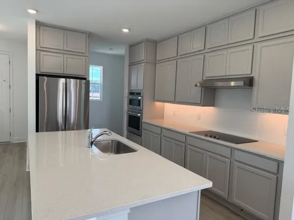 a kitchen with granite countertop a sink and a refrigerator