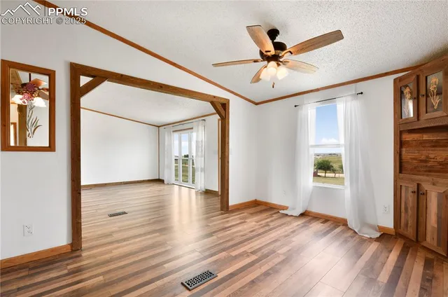 a view of a livingroom with wooden floor and a ceiling fan