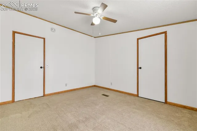 an empty room with a ceiling fan and a window