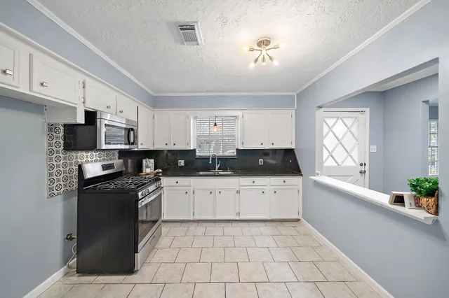 a large kitchen with stainless steel appliances granite countertop a stove a sink dishwasher and a refrigerator