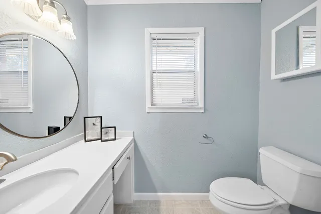 a bathroom with a sink a toilet and a mirror