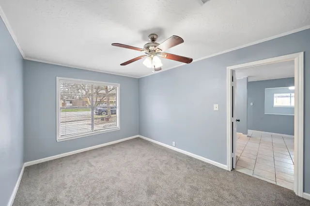 an empty room with fan and windows