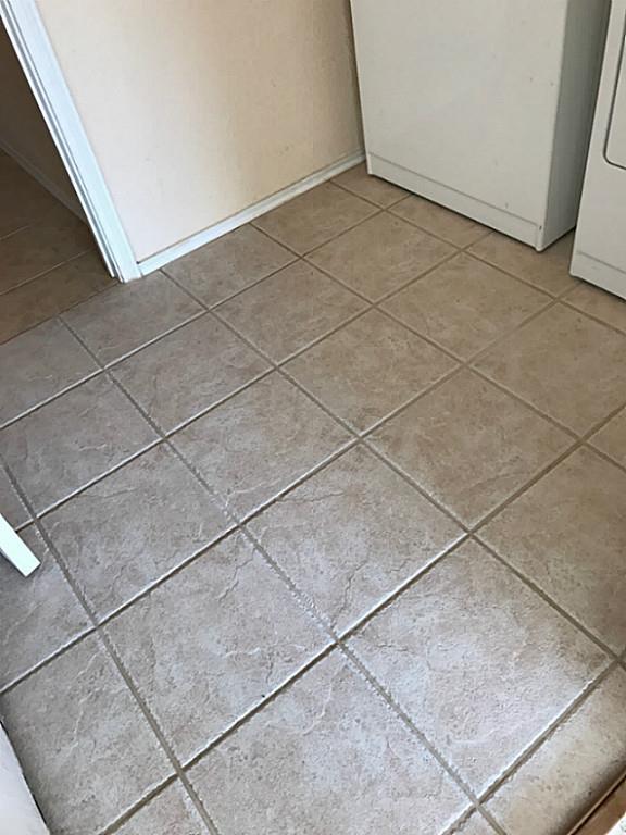 3142 Aspen Fair Trail Spring, TX 77389 - Photo 21 of 22 This photo shows a laundry area with a tan tiled floor and neutral walls, featuring a washer and dryer.