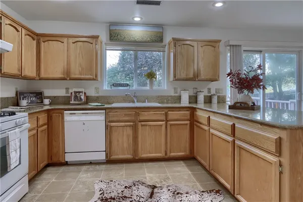 a kitchen with stainless steel appliances granite countertop a sink and cabinets