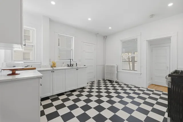 a kitchen with a checkered floor and white cabinets