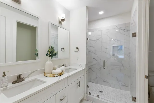 a bathroom with a shower sink and mirror