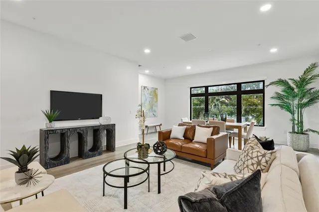 a living room with furniture a flat screen tv and a large window