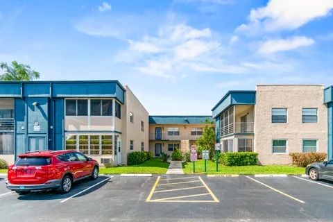 a front view of a building with a garden and barbeque oven