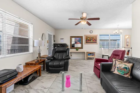 a living room with furniture ceiling fan and a window