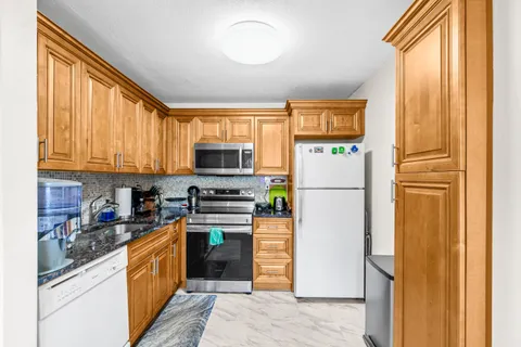 a kitchen with stainless steel appliances a refrigerator sink and microwave