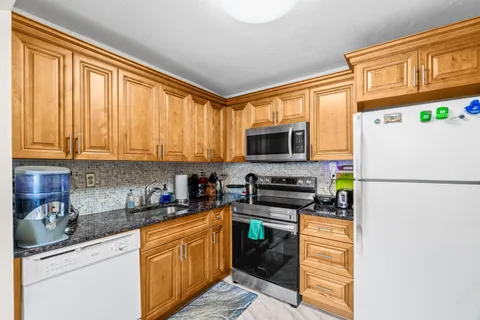 a kitchen with stainless steel appliances granite countertop a refrigerator stove microwave and sink
