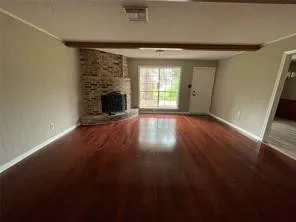 a view of an empty room with a fireplace and a window