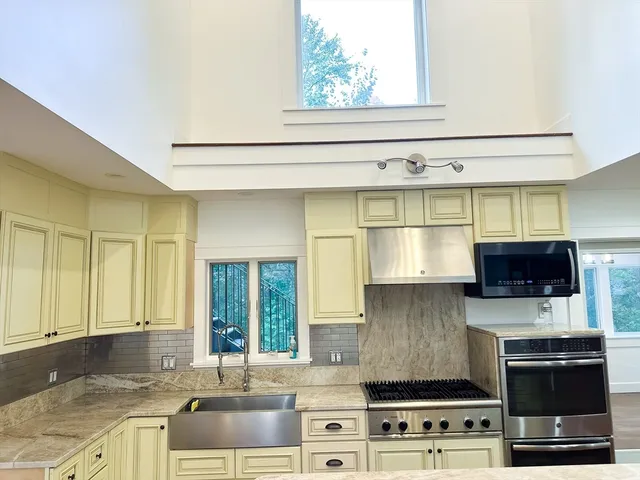 a kitchen with stainless steel appliances a stove a sink and a microwave