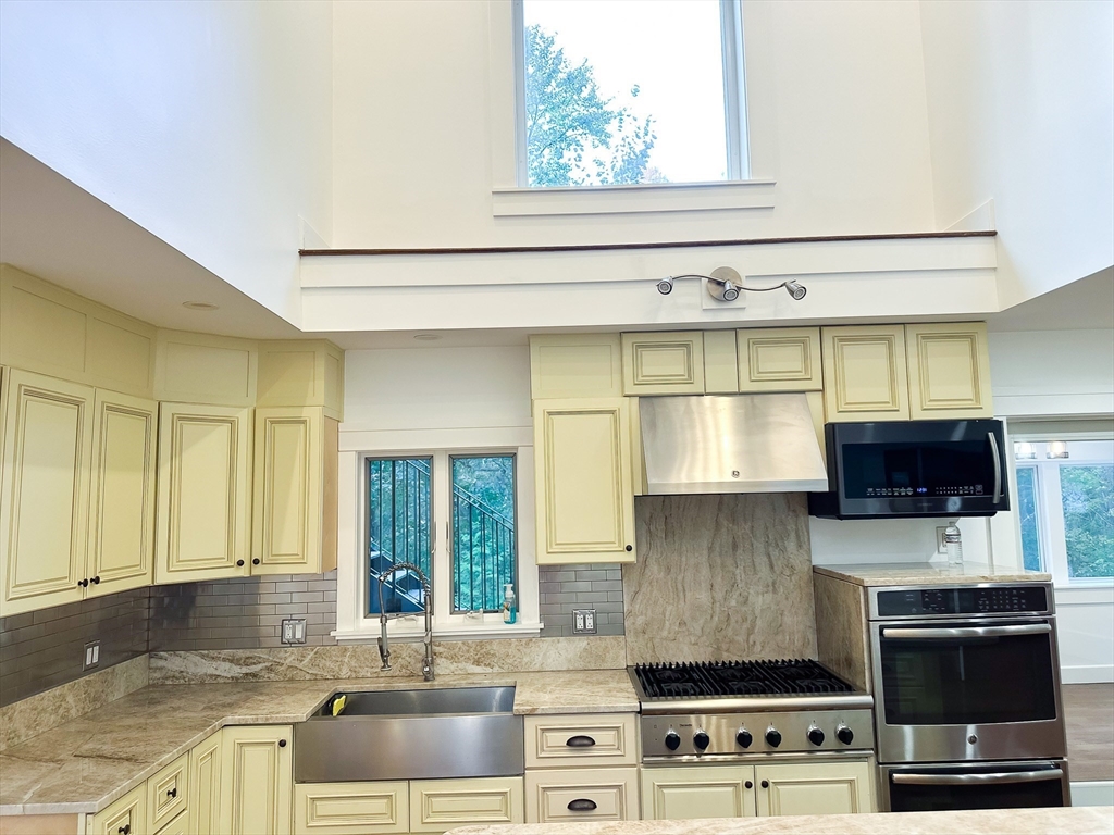 125 Maple Street Carlisle, MA 01741 - Photo 6 of 35 a kitchen with stainless steel appliances a stove a sink and a microwave