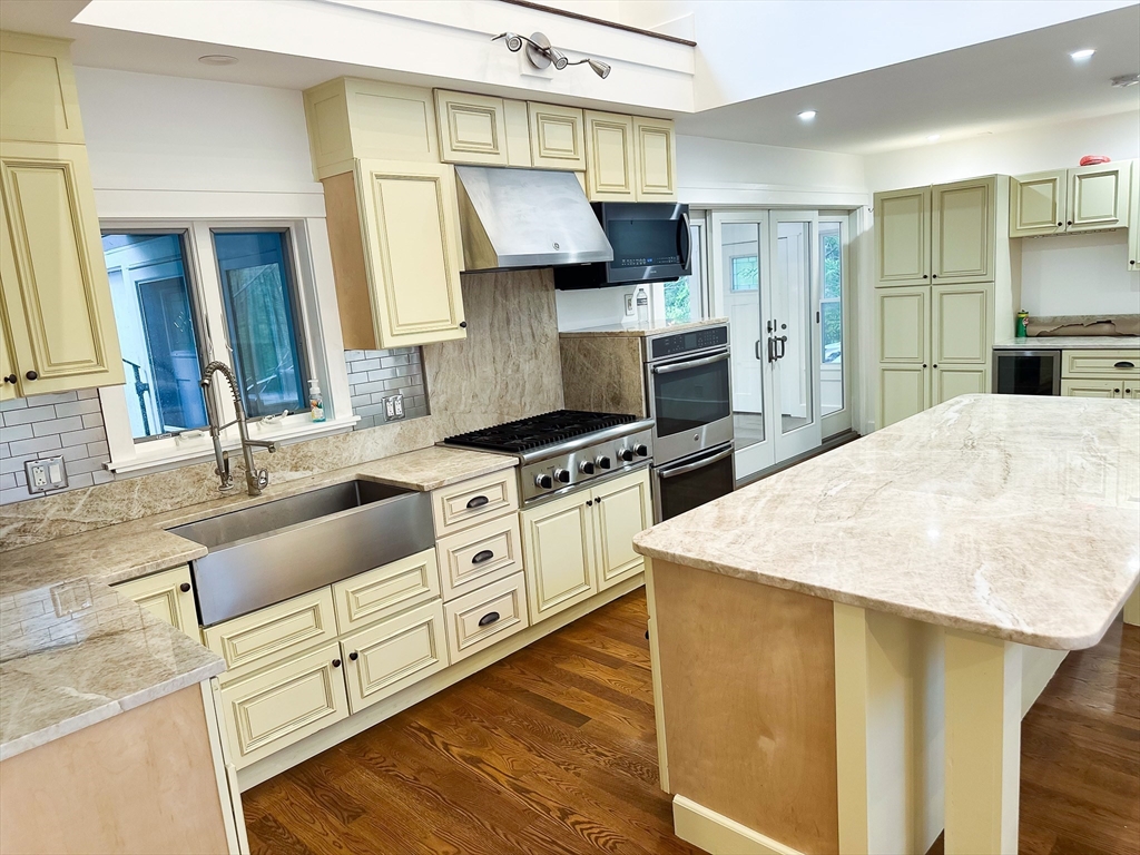 125 Maple Street Carlisle, MA 01741 - Photo 7 of 35 a kitchen with stainless steel appliances kitchen island granite countertop a sink stove and refrigerator