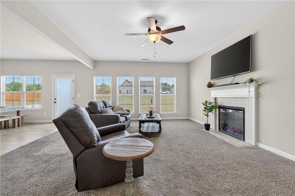 214 Millie Court Jackson, GA 30233 - Photo 13 of 61 a living room with furniture a fireplace and a flat screen tv