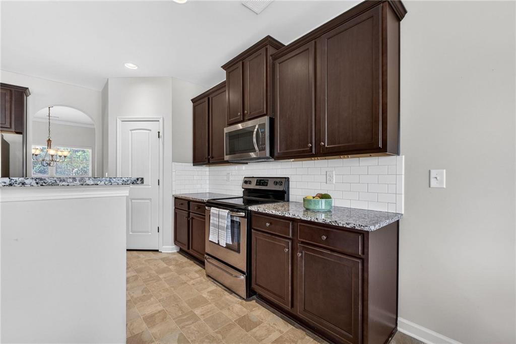 214 Millie Court Jackson, GA 30233 - Photo 18 of 61 a kitchen with stainless steel appliances granite countertop a stove a sink and a microwave