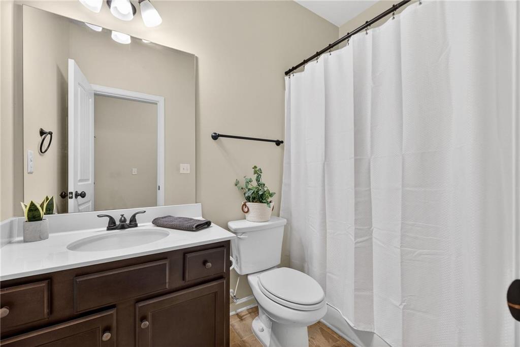 214 Millie Court Jackson, GA 30233 - Photo 27 of 61 a bathroom with a granite countertop sink a toilet and a mirror