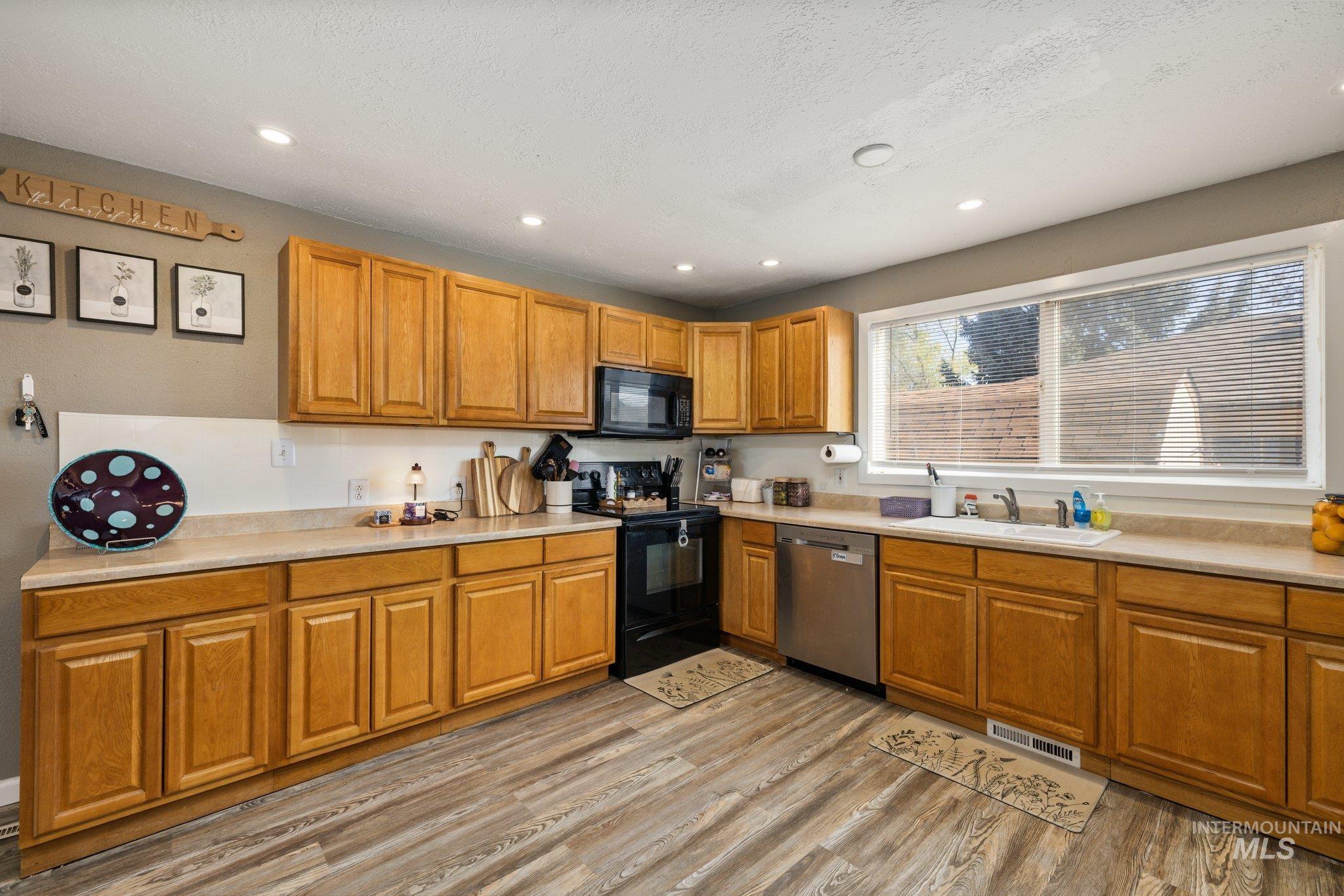 1504 2nd Street North Nampa, ID 83687 - Photo 10 of 29 Kitchen with black appliances, light countertops, wood finish cabinets, light wood-style floors, and recessed lighting