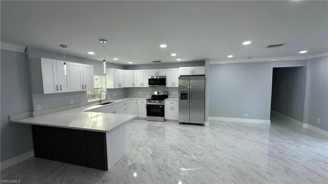 a large kitchen with stainless steel appliances granite countertop a large counter top and a oven