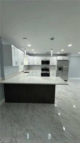 a kitchen with stainless steel appliances a refrigerator and a counter top space