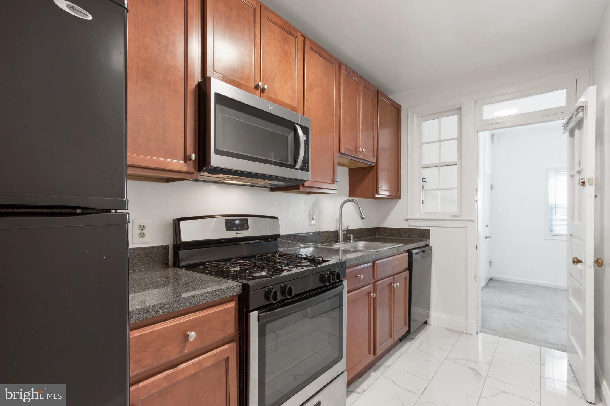 4500 MacArthur Boulevard Northwest Washington, DC 20007 - Photo 11 of 16 a kitchen with stainless steel appliances granite countertop a stove microwave and sink