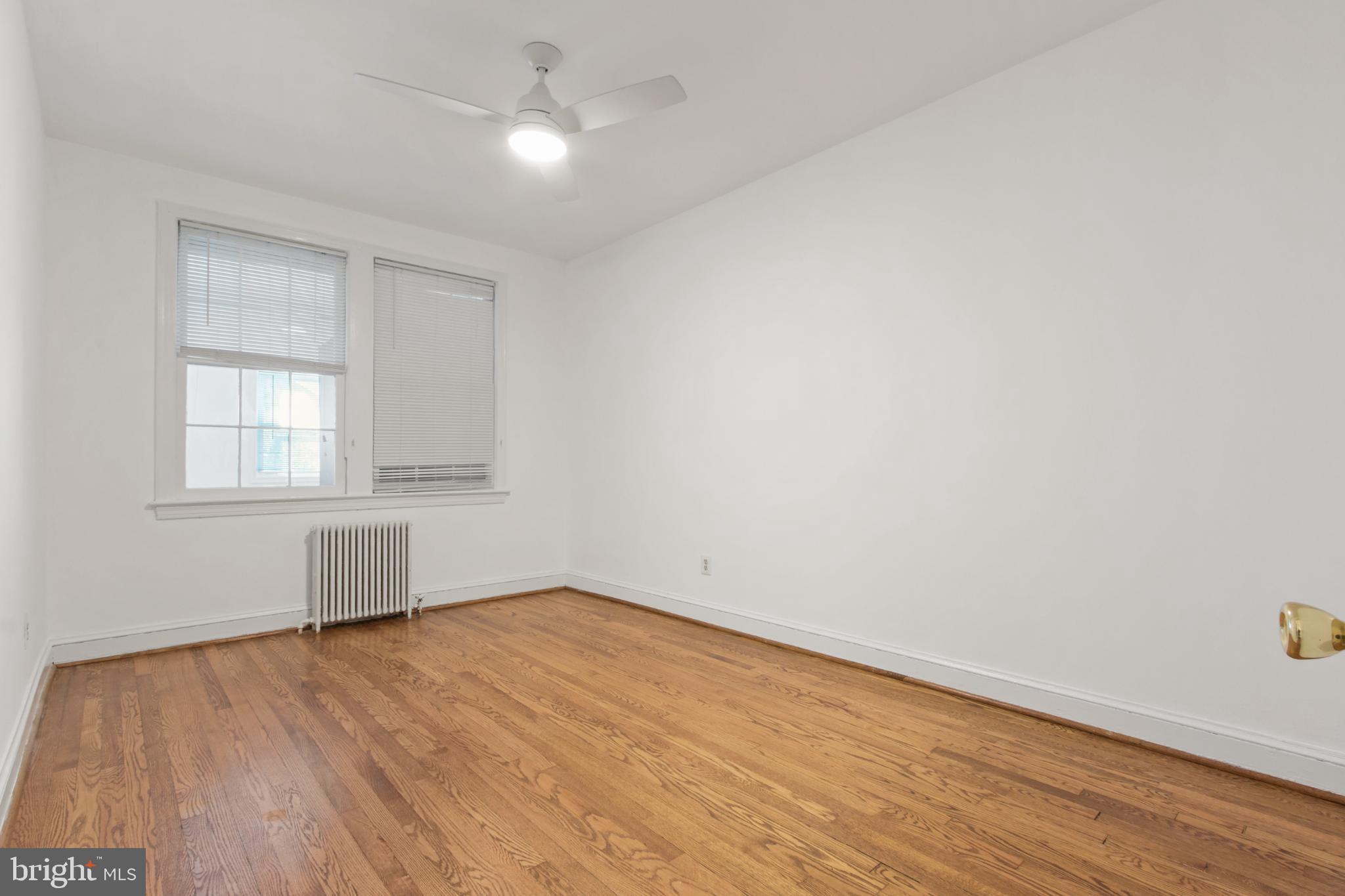 4500 MacArthur Boulevard Northwest Washington, DC 20007 - Photo 10 of 16 an empty room with wooden floor cabinet and windows